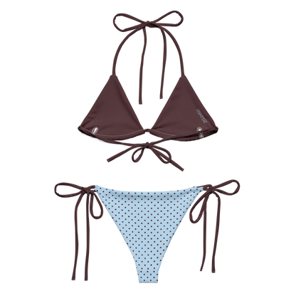Brown triangle bikini top and blue polka dot bikini bottom on a white background