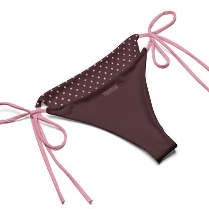 Brown bikini bottom with pink polka dot top and pink strings on a white background