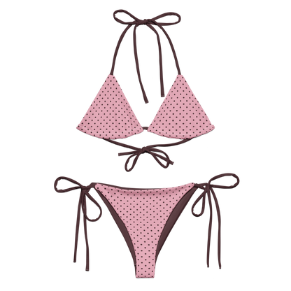 Pink polka dot bikini with brown straps on a white background