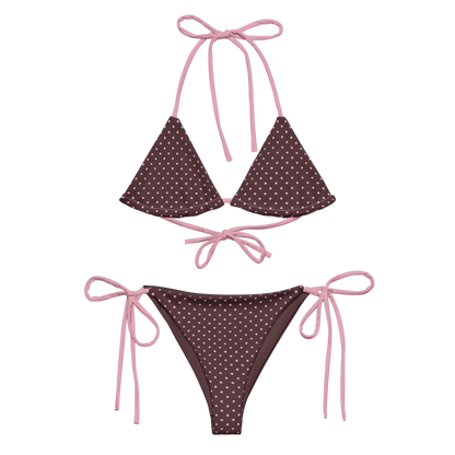Pink polka dot bikini set with pink strings on a brown background
