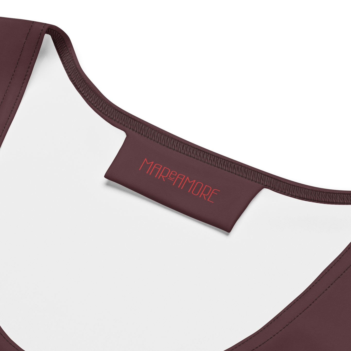 Close-up of a brown crop top with 'MAReAMORE' branding on a white background